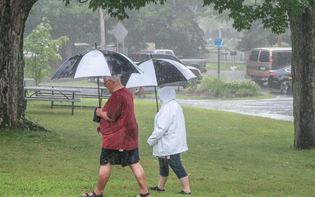 A couple walking in the rain with umbrellas