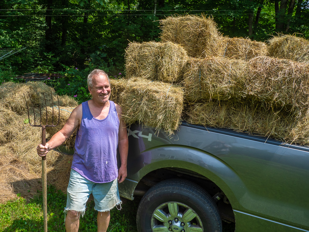 I pose with a truckload of hay for my garden